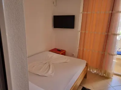 a small bedroom with a bed and a television at Vila DUBAI - ULCINJ VELIKA PLAŽA in Ulcinj
