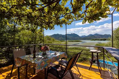 a table and chairs on a deck with a view at Lake House Buric in Vranjina
