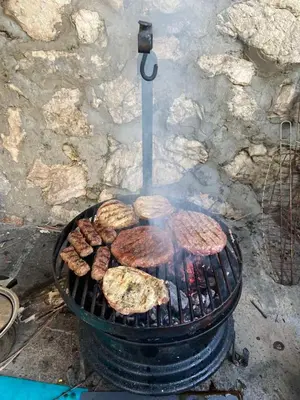 a grill with meat and hamburgers on it at Lake House Buric in Vranjina