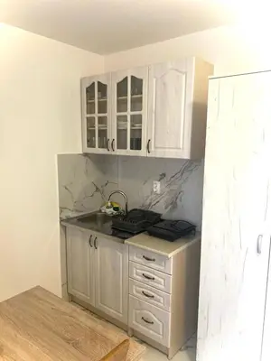 a kitchen with white cabinets and a counter top at Apartmani Orlović Bar in Bar