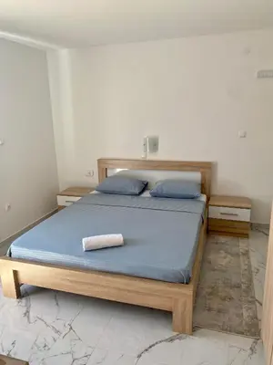 a bedroom with a bed with a towel on it at Apartmani Orlović Bar in Bar