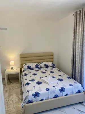 a bedroom with a bed with blue flowers on it at Apartmani Orlović Bar in Bar