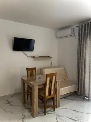 a room with a table and chairs and a bed at Apartmani Orlović Bar in Bar
