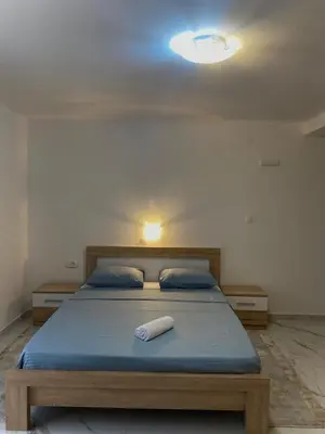 a bed in a room with a light on the ceiling at Apartmani Orlović Bar in Bar