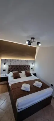 a bedroom with a large bed with two towels on it at Deluxe Apartmani Vila Pejovic Sutomore in Sutomore