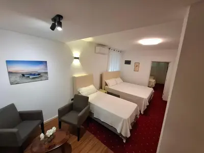 a hotel room with two beds and a chair at Titi Luxury&Spa in Ulcinj