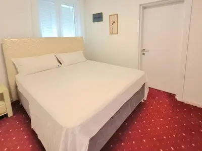 a bedroom with a white bed with a red carpet at Titi Luxury&Spa in Ulcinj