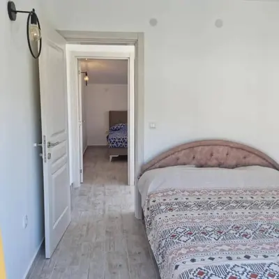 a bedroom with a bed and an open door at The Apartment in Ulcinj