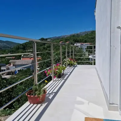 a balcony with potted plants on a building at The Apartment in Ulcinj