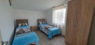 a bedroom with two twin beds and a large window at The Apartment in Ulcinj