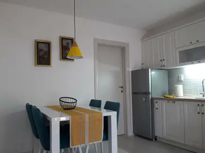 a kitchen with a table and chairs and a refrigerator at Budva center apartmant in Budva