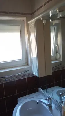 a bathroom with a sink and a mirror and a window at Budva center apartmant in Budva