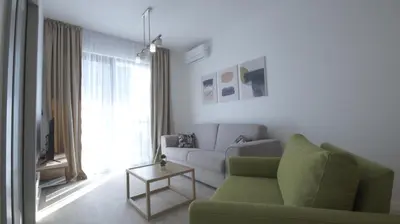 a living room with a green couch and a table at Silver Beachfront Becici in Becici
