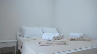 a white bed with towels and pillows on it at Silver Beachfront Becici in Becici