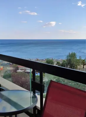 a balcony with a table and a view of the ocean at Silver Beachfront Becici in Becici