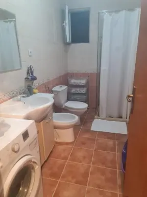 a bathroom with a toilet and a sink and a washing machine at Family apartment-DiLorena in Bar