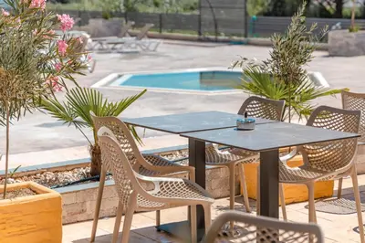 a table and chairs next to a swimming pool at Hotel Olea in Ulcinj