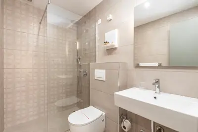 a white bathroom with a toilet and a sink at Hotel Olea in Ulcinj