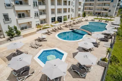 an overhead view of a pool with chairs and umbrellas at Hotel Olea in Ulcinj