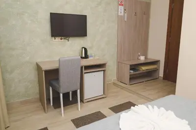 a room with a desk and a television on a wall at IPN ROOMs in Mahala