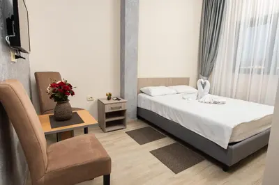a small bedroom with a bed and a chair at IPN ROOMs in Mahala