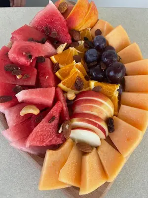 a plate of fruits and vegetables on a table at IPN ROOMs in Mahala