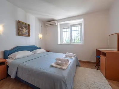 a bedroom with a blue bed with towels on it at Tomy Garden House in Budva