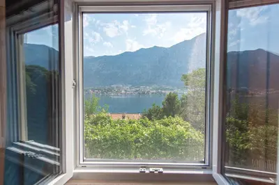 a window with a view of a lake and mountains at BARBARA101 in Kotor