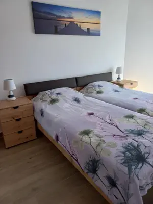 a bedroom with a bed with a floral bedspread at Sea View Dobra Voda in Dobra Voda
