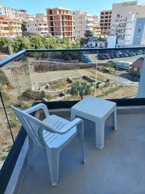 a white chair and a table on a balcony at Sea View Dobra Voda in Dobra Voda