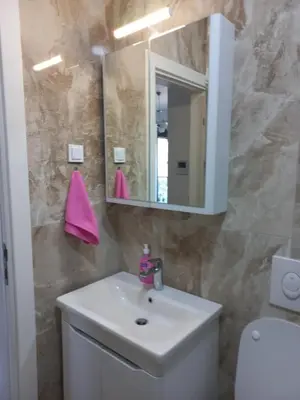 a bathroom with a white sink and a mirror at Sea View Dobra Voda in Dobra Voda