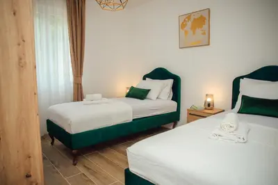 a bedroom with two beds with green and white sheets at Baia di Cattaro in Kotor