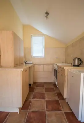 a kitchen with wooden cabinets and a tile floor at Apartments Radimir in Kotor