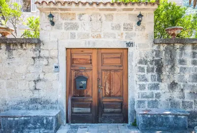 a wooden door on the side of a stone building at Apartments Radimir in Kotor