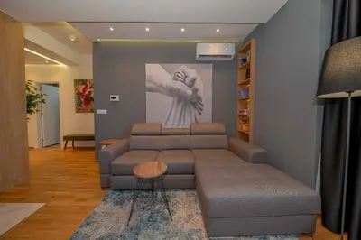 a living room with a couch and a painting on the wall at Night Pearl - Deluxe Apartment in Bar