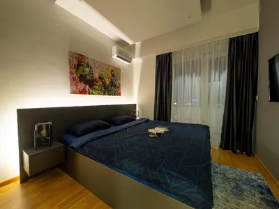 a bedroom with a large blue bed in a room at Night Pearl - Deluxe Apartment in Bar