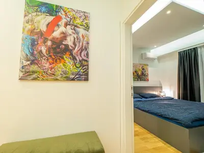 a bedroom with a painting hanging on the wall at Night Pearl - Deluxe Apartment in Bar