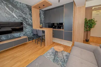 a living room with a couch and a kitchen at Night Pearl - Deluxe Apartment in Bar