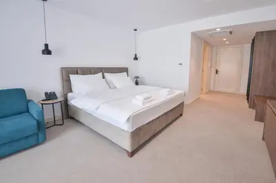 a bedroom with a large bed and a blue couch at Hotel Riva in Budva