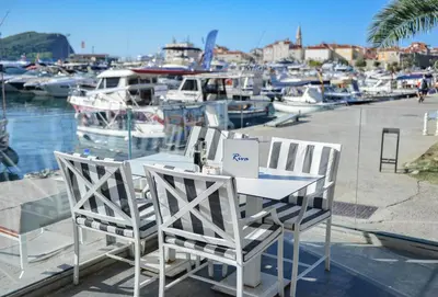 a table and chairs with boats in a marina at Hotel Riva in Budva