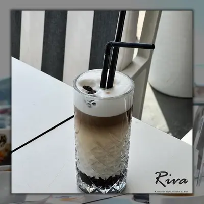 a drink with a straw sitting on a table at Hotel Riva in Budva