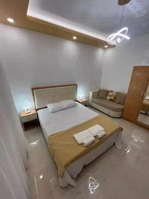 a bedroom with a large bed and a couch at City Heart Apartments in Ulcinj