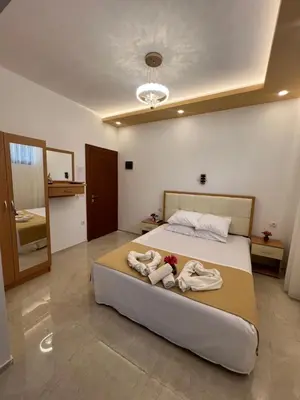 a bedroom with a large bed with towels on it at City Heart Apartments in Ulcinj