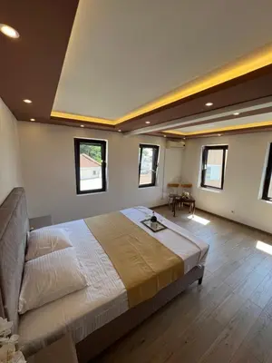 a large bedroom with a large bed and windows at City Heart Apartments in Ulcinj
