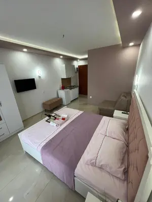 a bedroom with a large bed and a living room at City Heart Apartments in Ulcinj