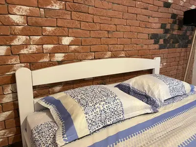 a bed in front of a brick wall at Una Apartment Cetinje in Cetinje