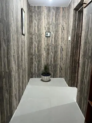 a room with a wooden wall with a potted plant at Una Apartment Cetinje in Cetinje