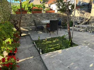 a patio with a table and chairs and flowers at Una Apartment Cetinje in Cetinje