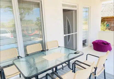 a glass table and chairs on a balcony at Sam Villa in Ulcinj