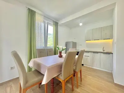 a kitchen and dining room with a table and chairs at Talia Apartments in Budva